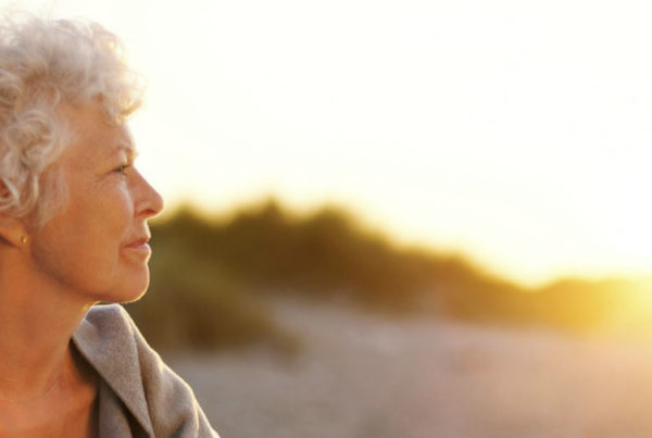 elderly senior-woman-on-beach-looking-into-horizon-cropped