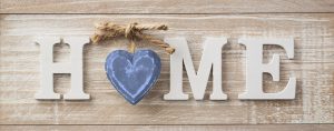 Wooden sign reading, "Home." We are more than respite care. We provide the comfort of family.
